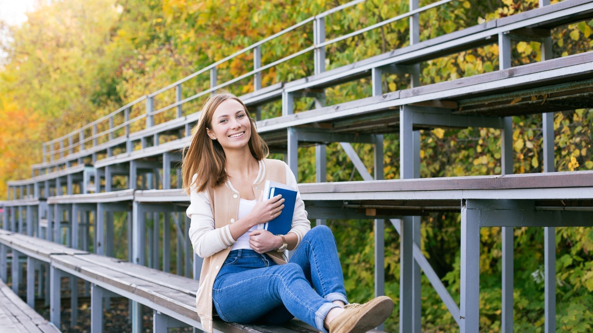 Student Sitting On Sport Tribune With Book